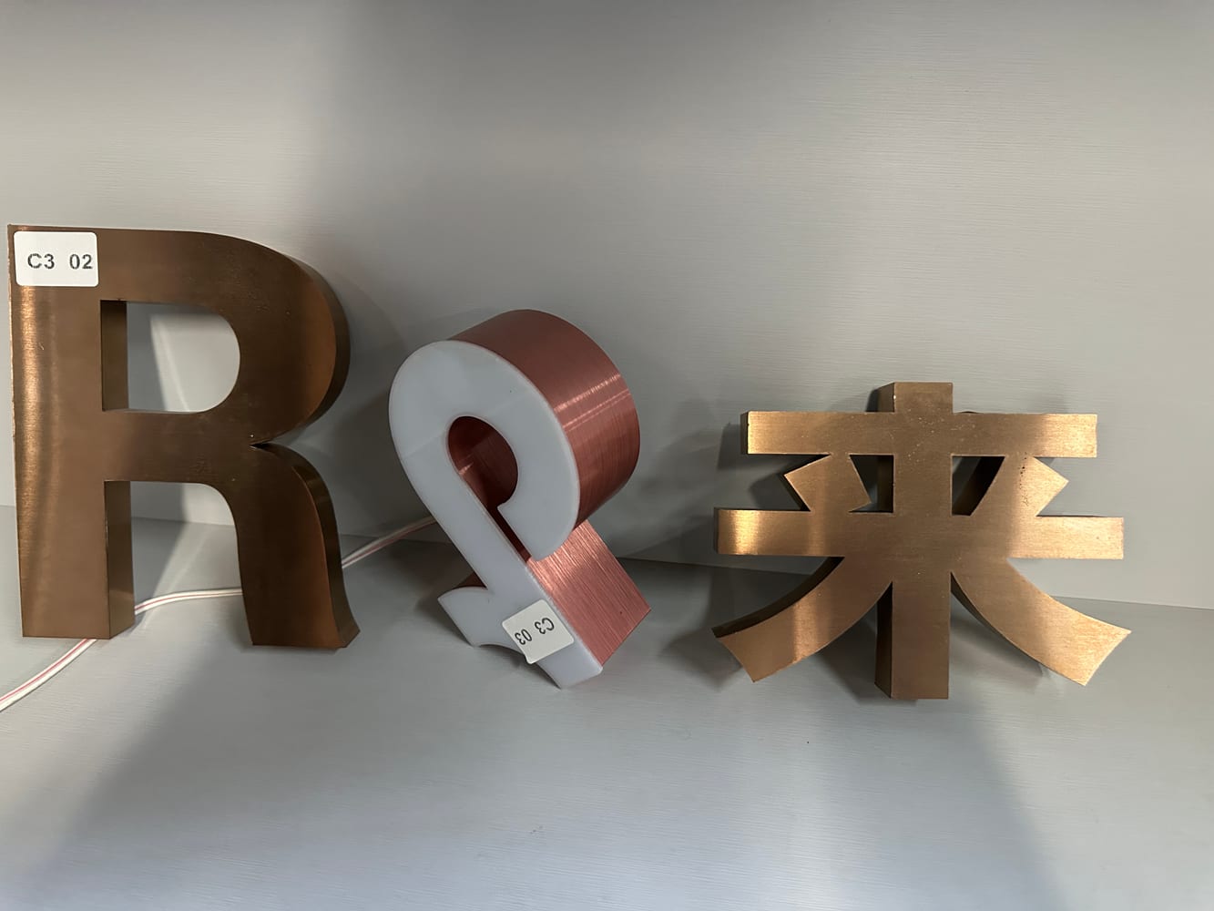 广告字围边材料真实案例图，展示不锈钢广告字和围边样品